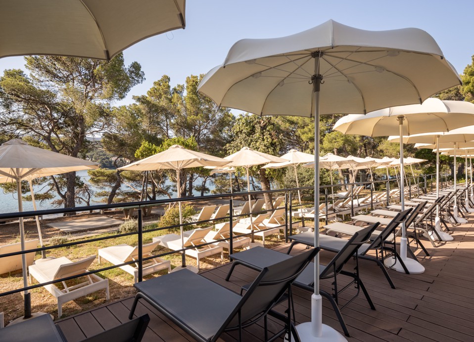 Sunbeds and parasols by the pool at Aminess Younique Senses Resort on Hvar Island with sea view