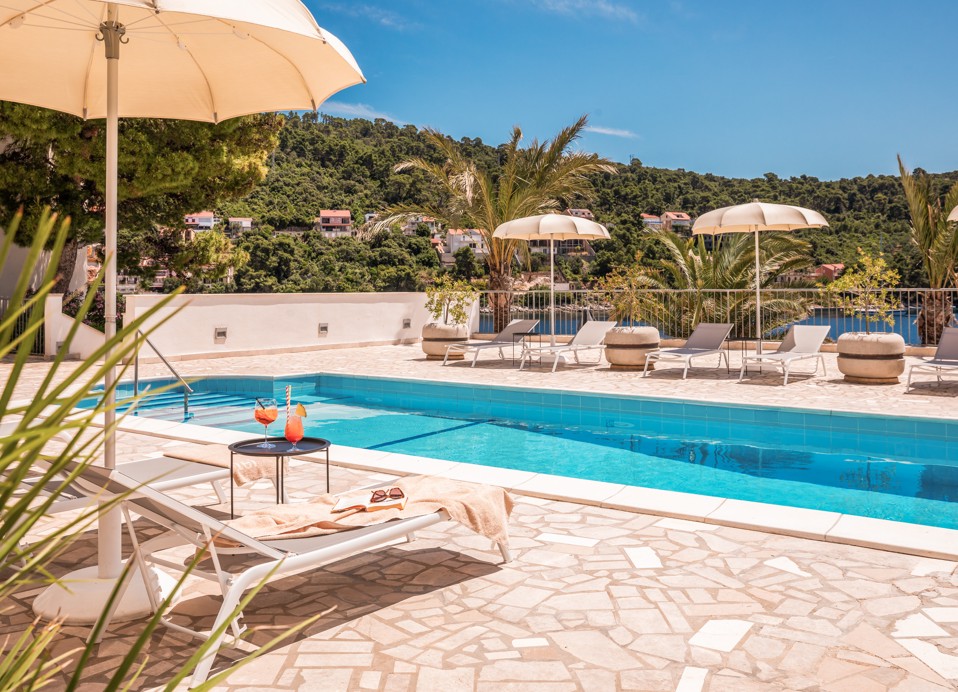 Pool area at Aminess Lume Hotel with sunbeds and Mediterranean greenery