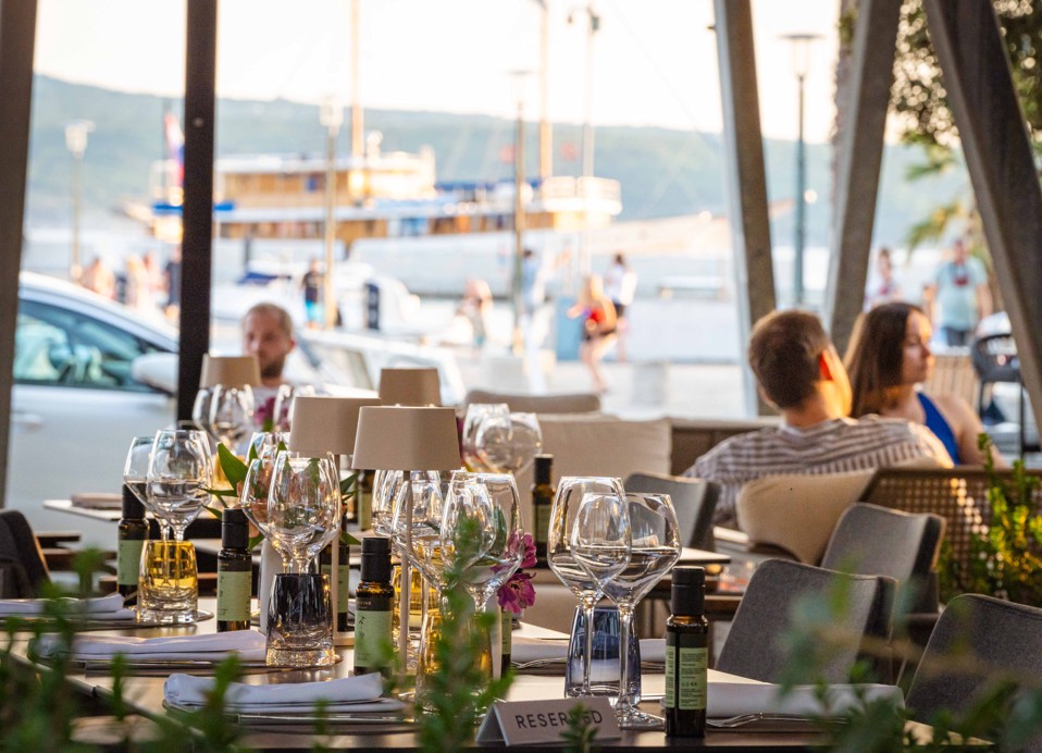 Outdoor terrace seating with a view at Aminess Younique Narrivi Hotel restaurant.