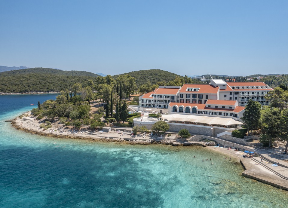 Beachfront view near the hotel with crystal-clear sea and lush green surroundings near Aminess Younique Liburna Hotel.