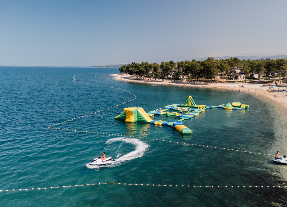 Zračni pogled na vodno igralište uz plažu u Aminess Style Camping Avalona Resortu, atrakcija puna zabave za djecu i odrasle tijekom ljetnog odmora na Pagu.