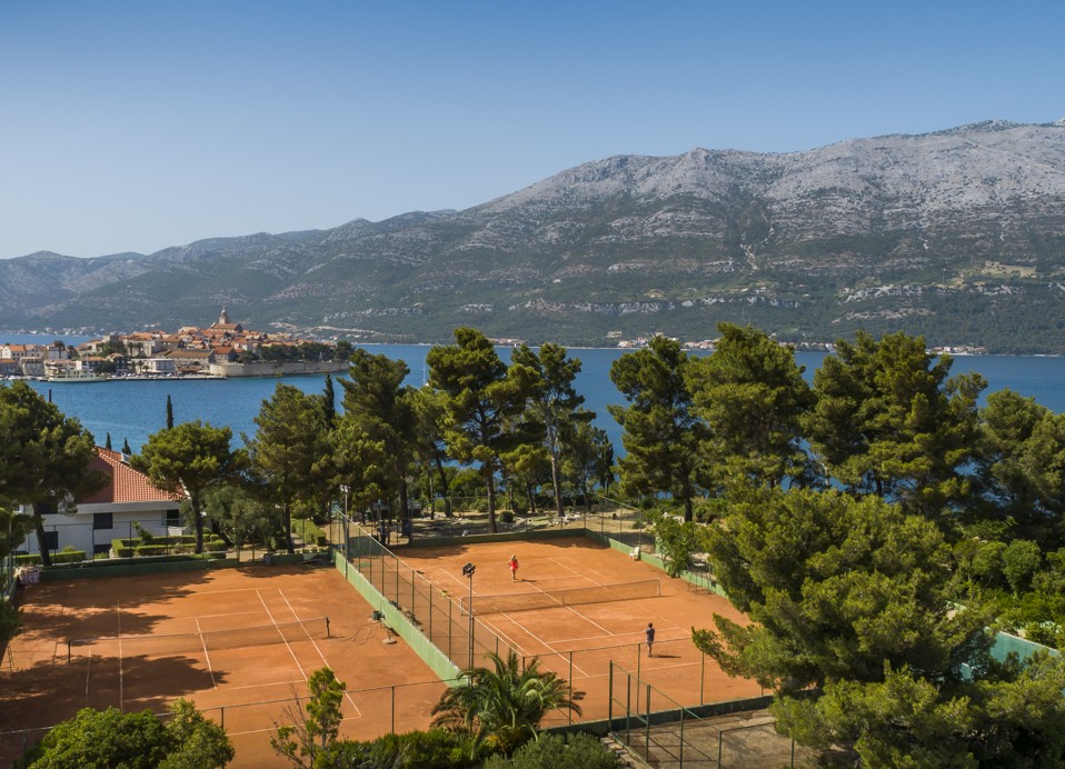 Due campi da tennis all'aperto con una vista mozzafiato sul Mare Adriatico, le montagne e la storica città di Korcula presso l'Aminess Younique Liburna Hotel.