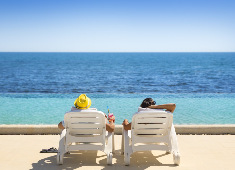 Een stel ontspant op een ligstoel met een cocktail in de hand.