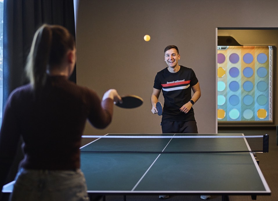 Adolescenti che giocano a ping-pong nella sala giochi.