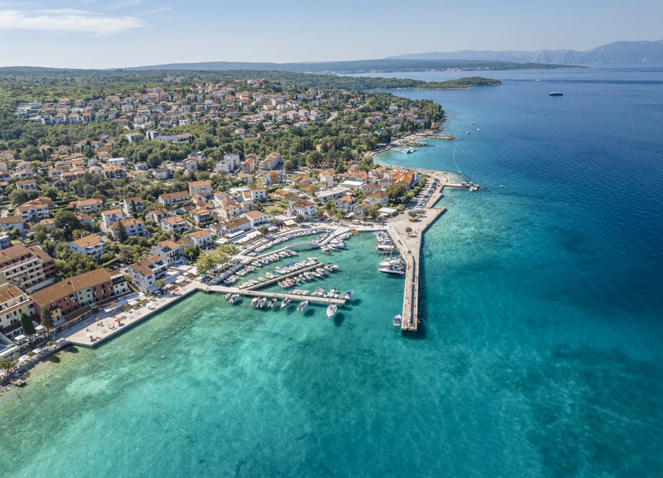 Eine atemberaubende Luftaufnahme des kristallklaren Wassers und des wunderschönen Strandes in der Nähe des Veya Maradiso Hotels von Aminess.