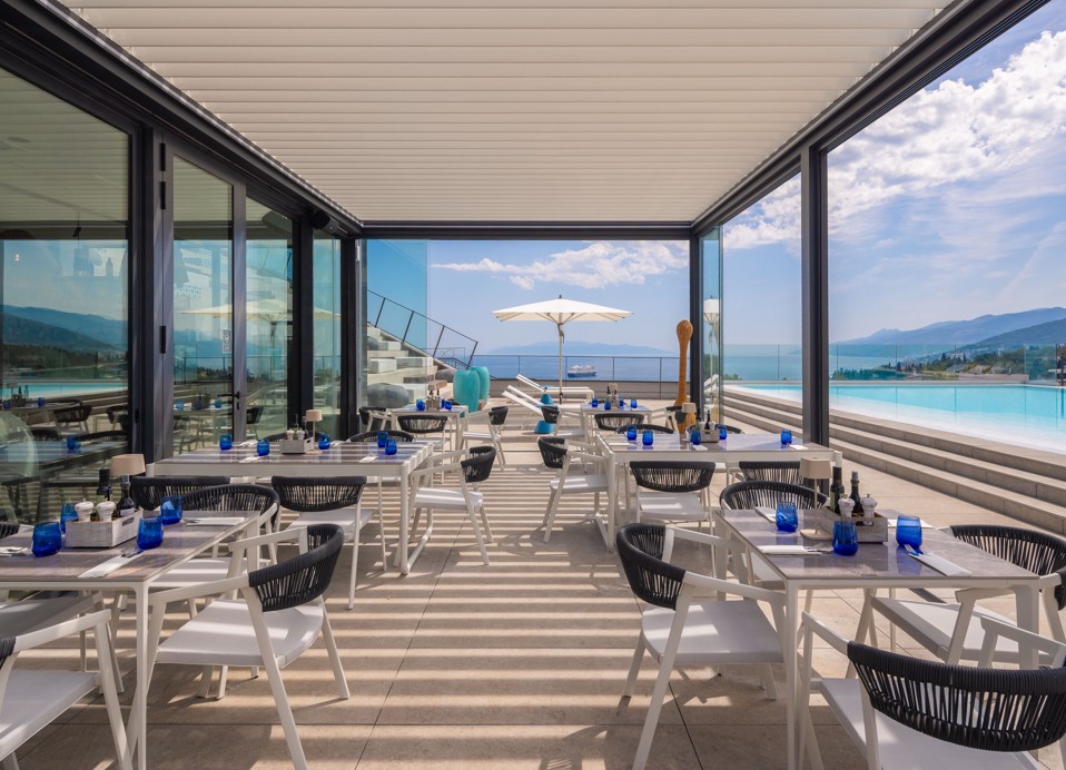 Rooftop terrace of Il Cantuccio restaurant and bar with lounge seating, sun shades and open sea views