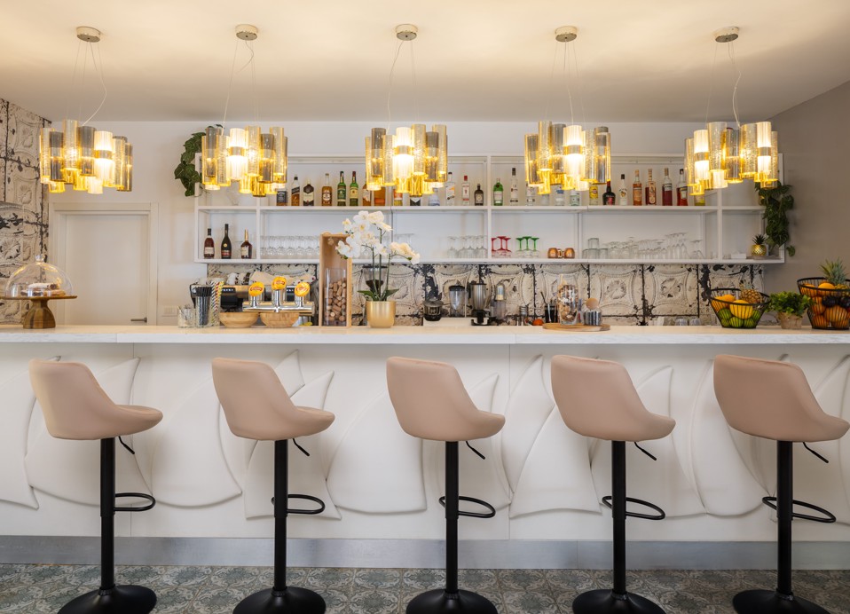 Bar Noir at Younique Bellevue Hotel by Aminess with bar stools and pendant lights.