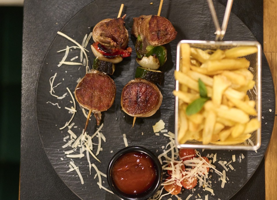 Meat and vegetable skewers with fries and sauce at Aminess Kadoor Hotel.