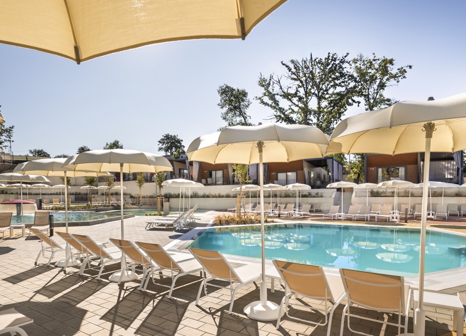 Complesso di piscine con palme e lettini bianchi nel campeggio Aminess Atea sull’isola di Krk