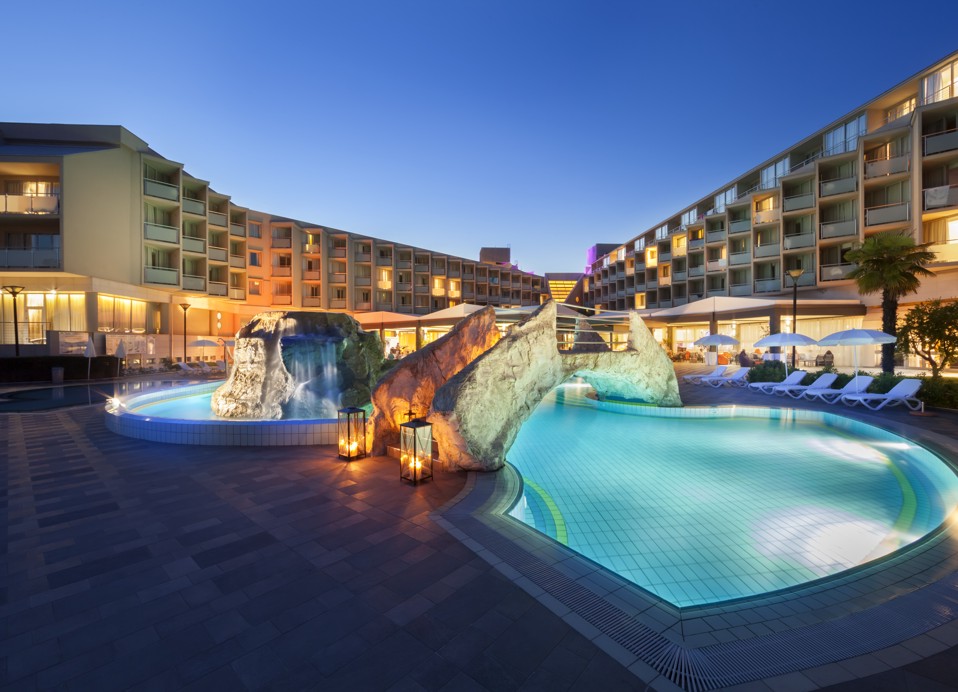 Vanjski bazen hotela, osvijetljen noćnim svjetlima.