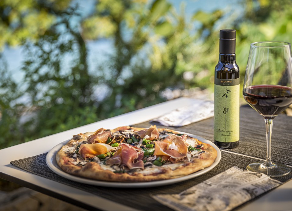 Traditional Italian pizza served at Il Cantuccio restaurant at Aminess Vival Port9 Resort, Korcula, paired with olive oil and a glass of wine.