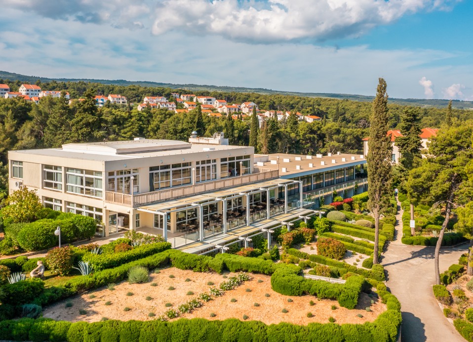 Panoramski pogled na restavracijo Oliveto v letovišču Aminess Vival Velaris na Braču, obdano z borovci in urejenimi vrtovi