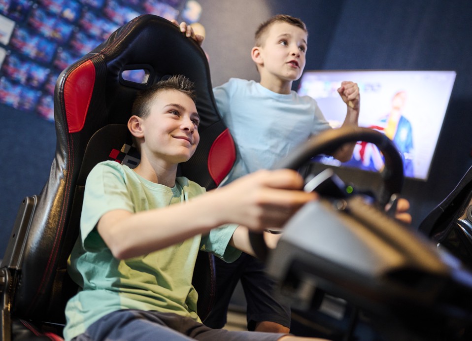 Jongens spelen een racespel in een gamingruimte met een rijsimulator