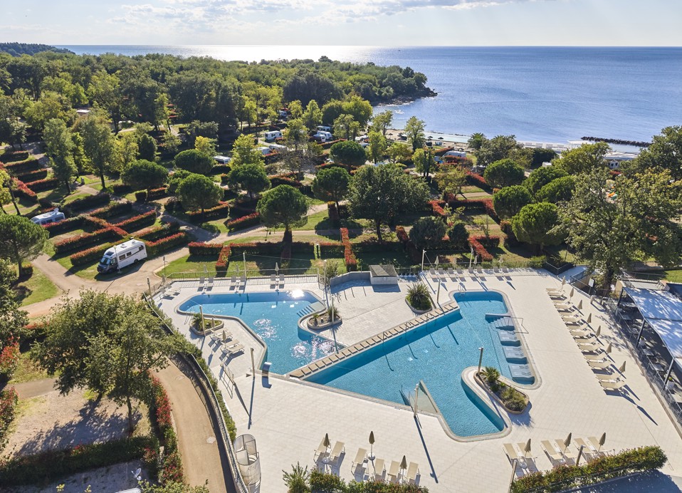 Panoramisch uitzicht op het zwembad en het strand bij Aminess Planet Camping Maravea Resort, omgeven door groen, perfect om te ontspannen en van de vakantie te genieten