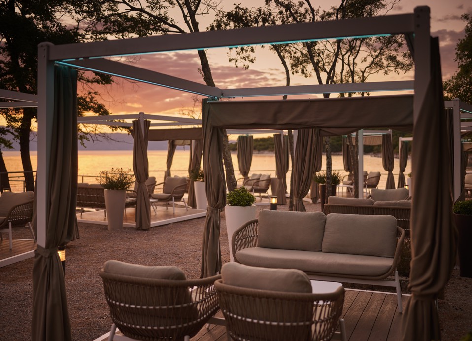 Gasten ontspannen in een cabana bij Punto Mare in de buurt van Magal Maradiso Hotel door Aminess, omgeven door groen en uitzicht op zee.