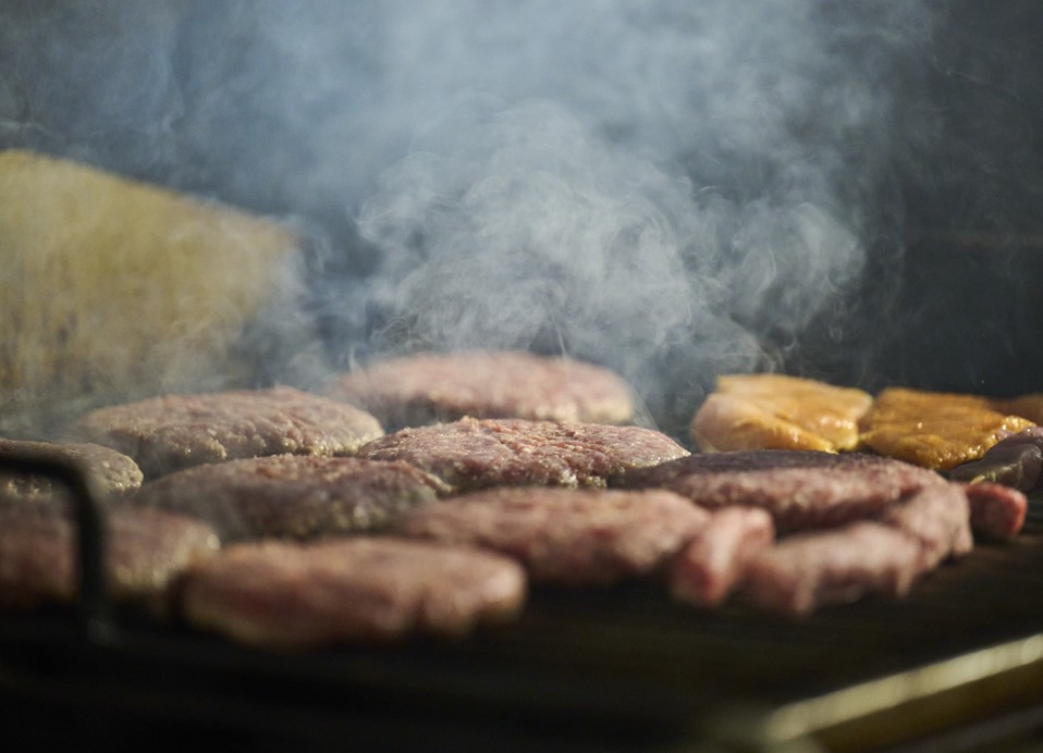 Primer natančnega posnetka burgerjev in čevapčičev, ki se pečejo na žaru, obdanih z dimno atmosfero v bližini Aminess Style Camping Atea Resort.