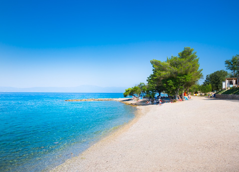 Ein ruhiger Strandplatz mit kristallklarem Wasser in der Nähe des Veya Maradiso Hotels von Aminess.