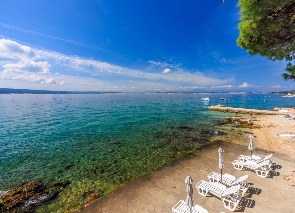 Area fronte mare presso l'Hotel Mediteran Maradiso di Aminess con comode sdraio posizionate.