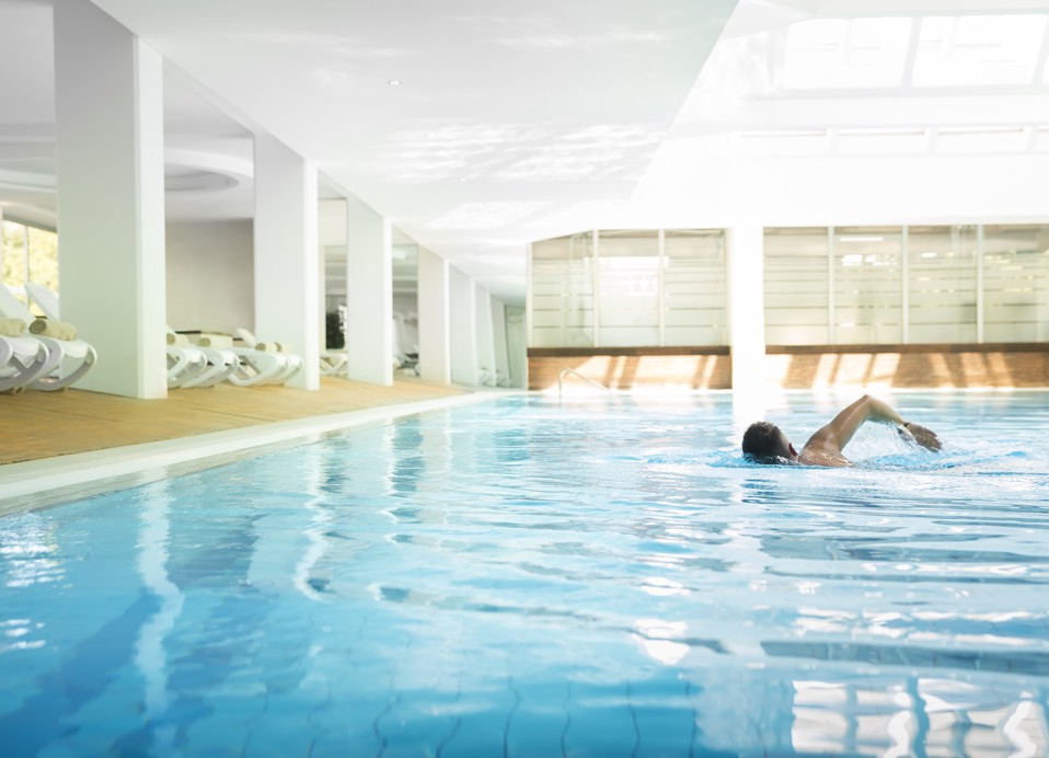 Een man zwemt in het binnenzwembad van het wellnessgedeelte.