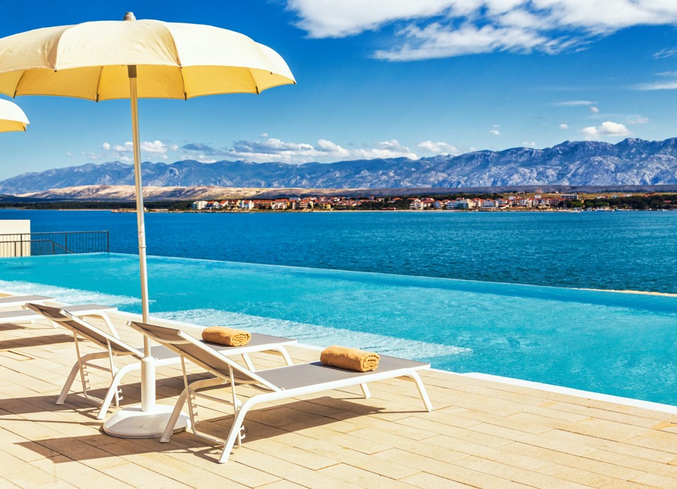 Sonnenliegen mit Sonnenschirm am Entspannungspool im Aminess Style Camping Avalona Resort.