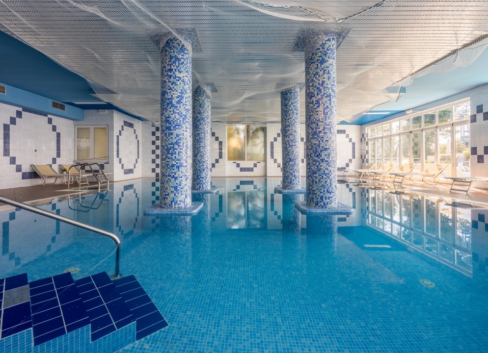 Piscina interna presso l'Hotel Mediteran Maradiso di Aminess con comode sdraio e un'atmosfera serena.