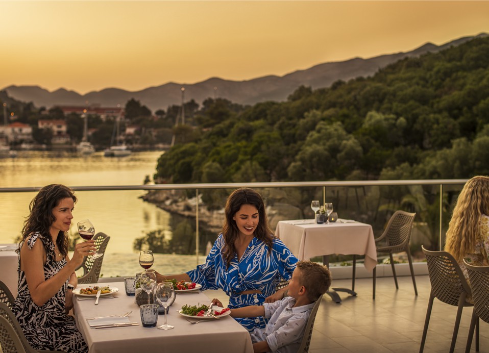 Gosti uživaju u obroku na terasi restorana, s prekrasnim pogledom na zalazak sunca unutar resorta, blizu Port9 Planet Camping by Aminess.