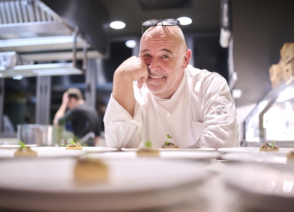 Lo chef Zirojević nella cucina a vista del ristorante rooftop The Above, mentre presenta piatti gourmet moderni in un elegante ambiente Aminess