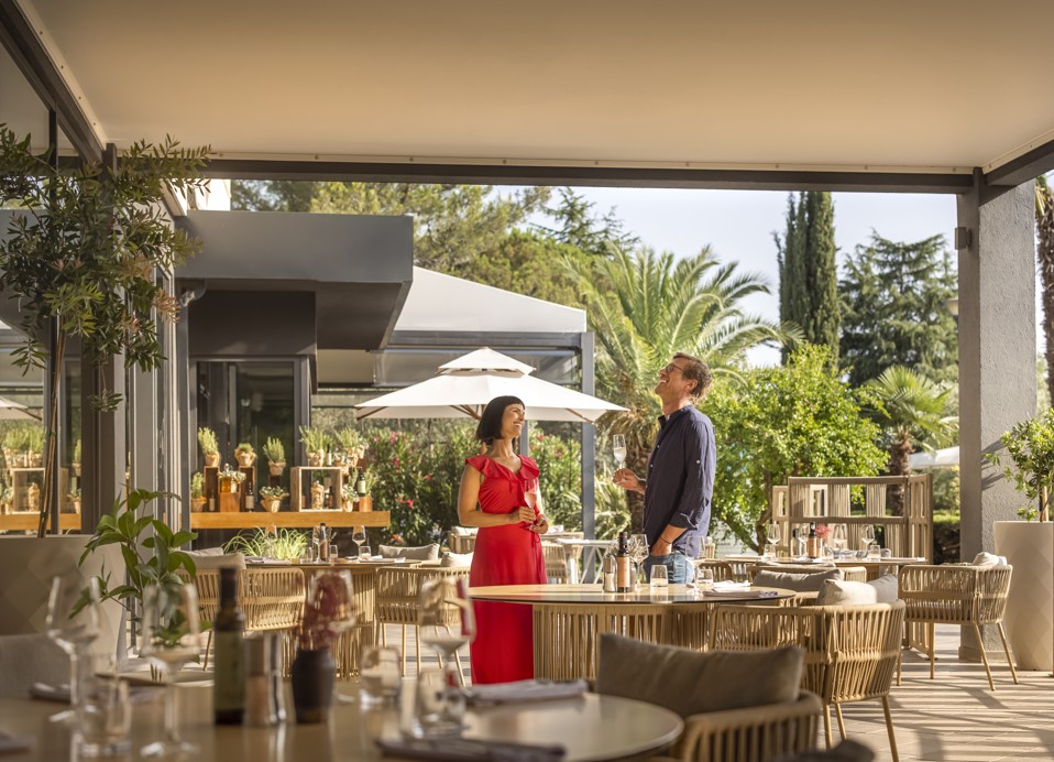 Een stel geniet van mousserende wijn op het buitenterras van het restaurant.