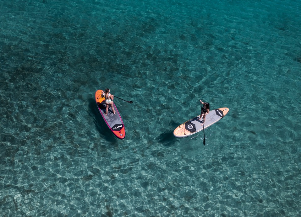 Aerial view of two girls on standing SUP-s