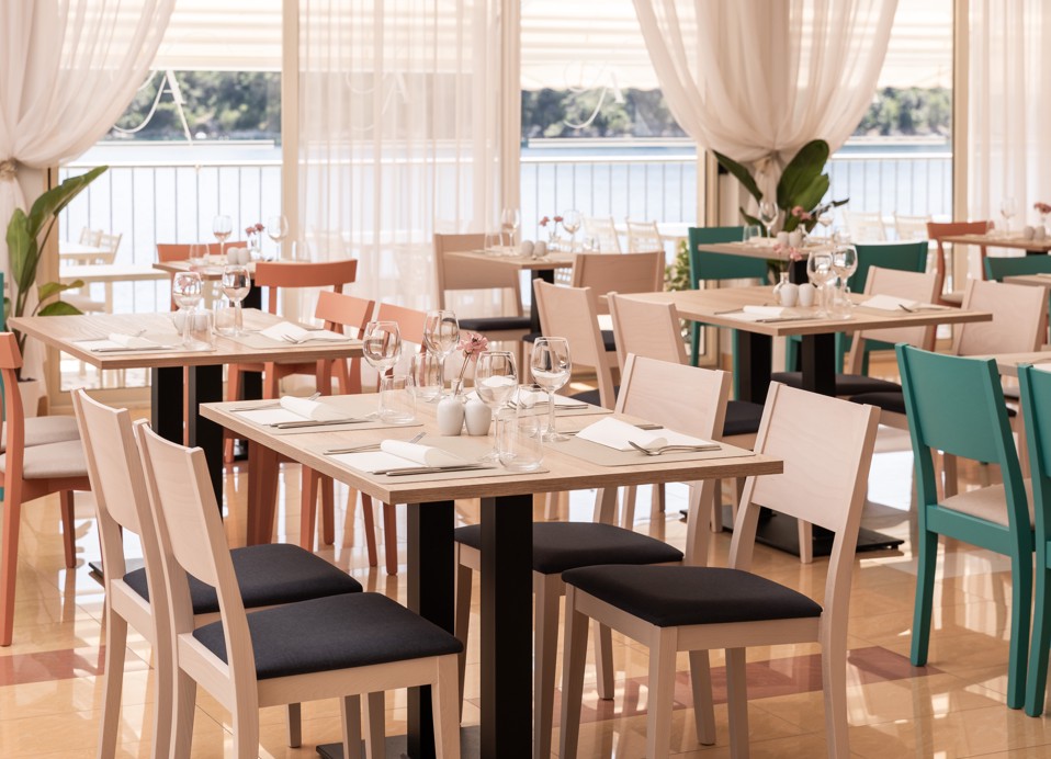 Speisebereich im Restaurant Unico mit großen hellen Fenstern