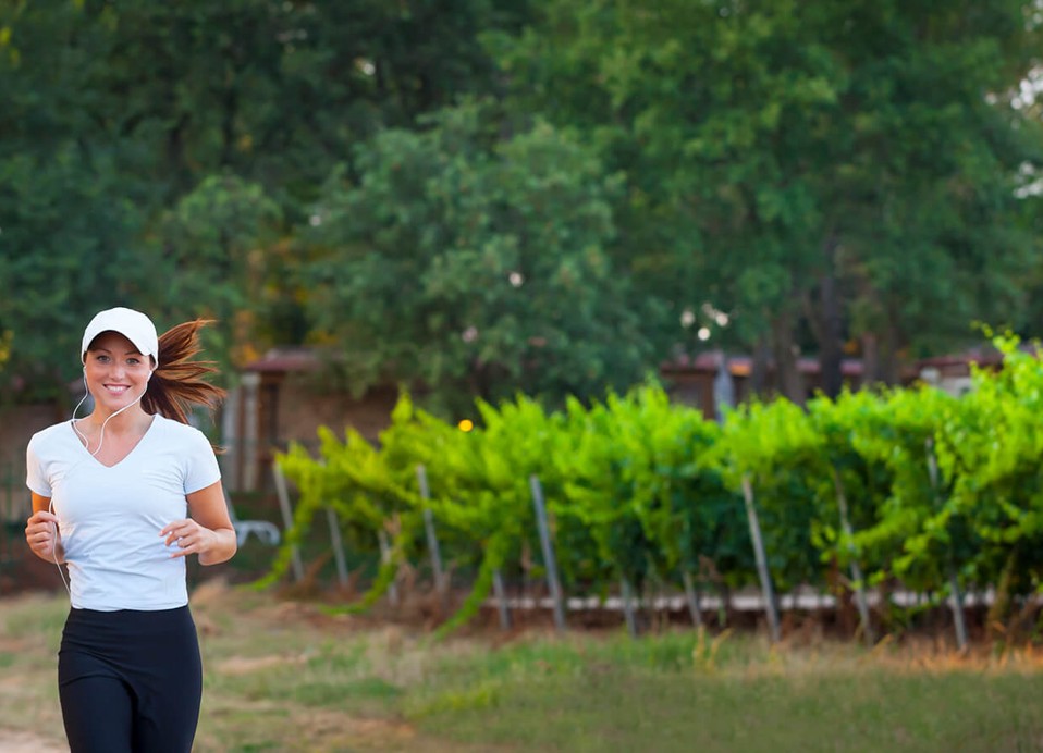 A women running next to a wineyard at Aminess Planet Camping Maravea Resort, Novigrad Croatia