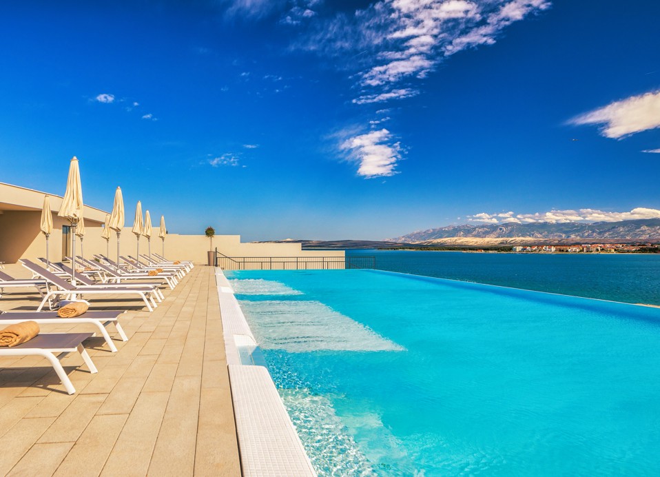 Sonnenliegen aufgereiht neben dem Entspannungspool im Aminess Style Camping Avalona Resort.