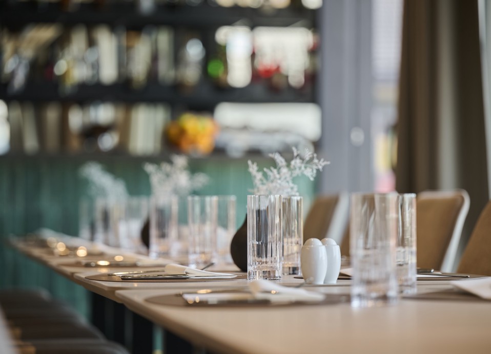 Nakryty stół ze szklankami i sztućcami w restauracji Aminess Florian & Godler Hotel.