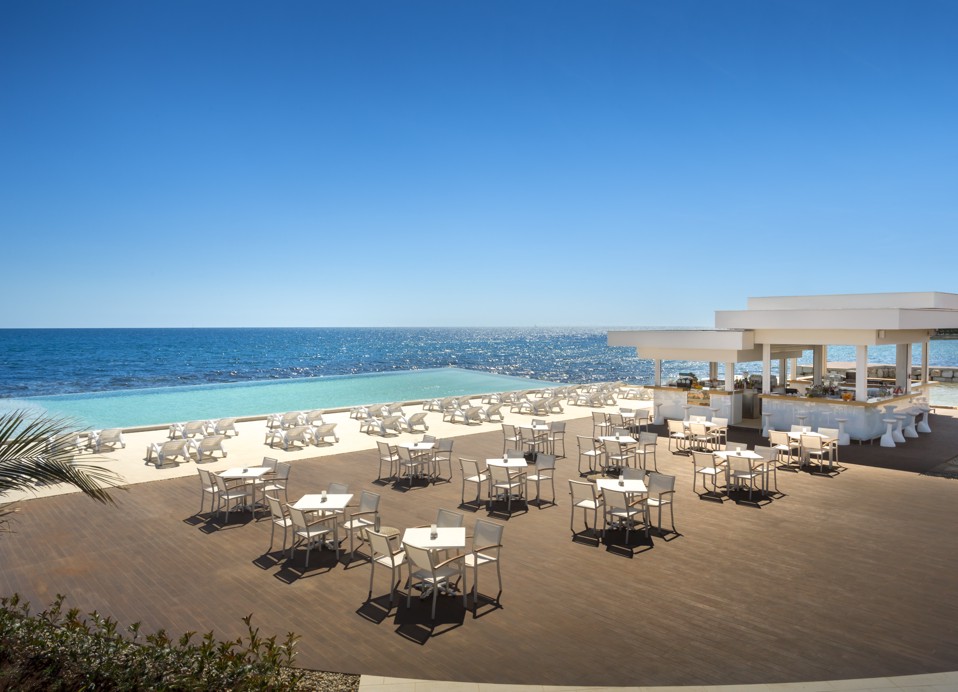 Luchtfoto van de Punto Mare Zone met de bar, ligstoelen, infinity pool en de zee.