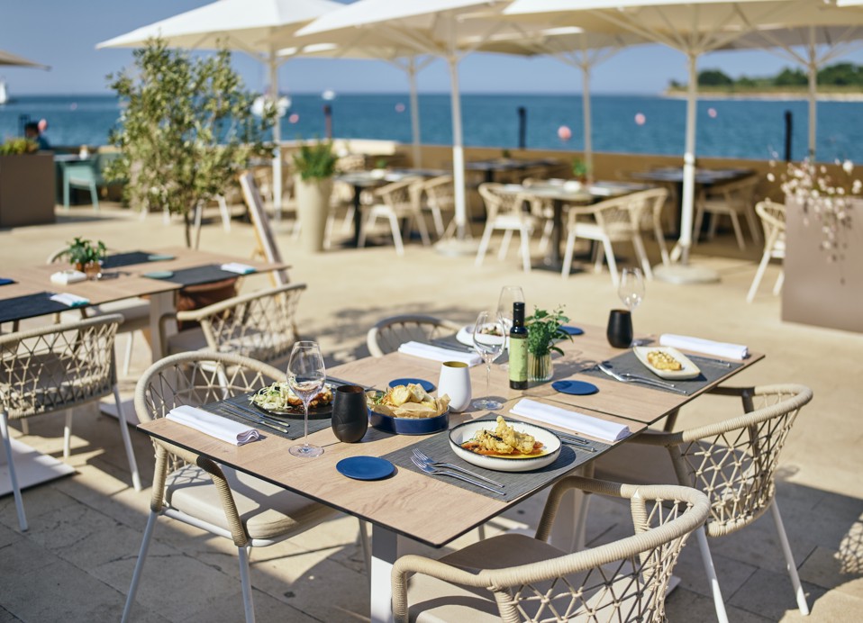 Terras met zeezicht van restaurant Half 8 met gedekte tafels