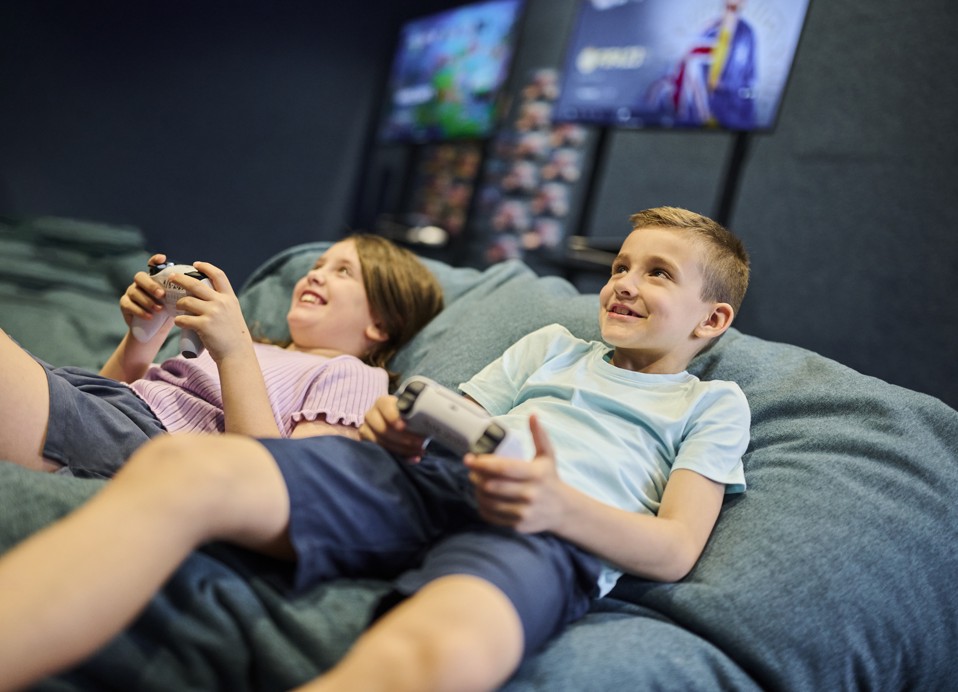 Een jongen en een meisje spelen ontspannen videogames op een console in de gamingruimte