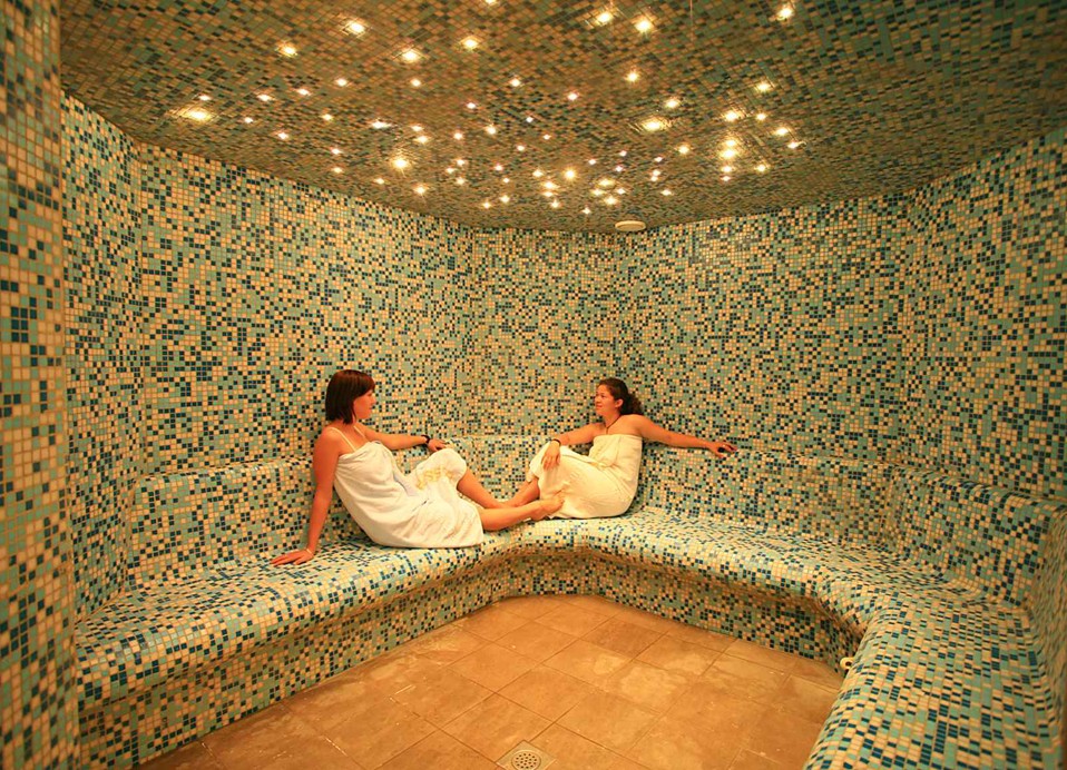 A serene spa area with guests relaxing on heated mosaic loungers, enveloped in a calming ambiance at the Maradiso Marko Polo by Aminess.