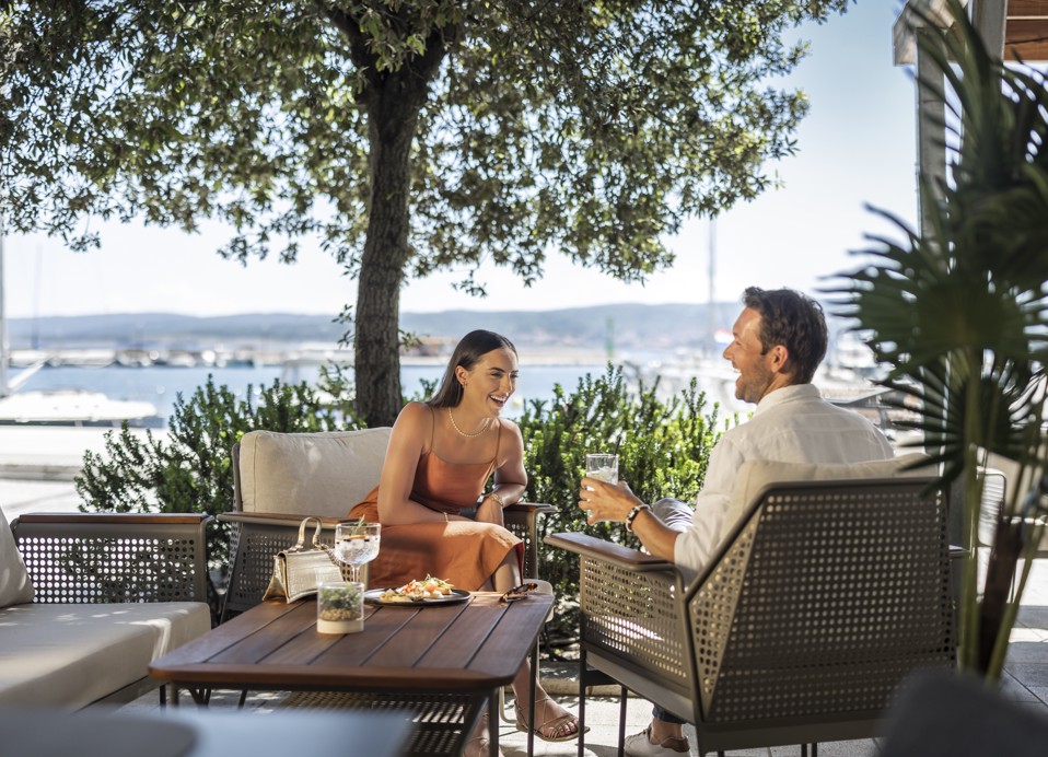 Couple dining on the terrace with a sea view at Half8 restaurant at Aminess Younique Narrivi Hotel.