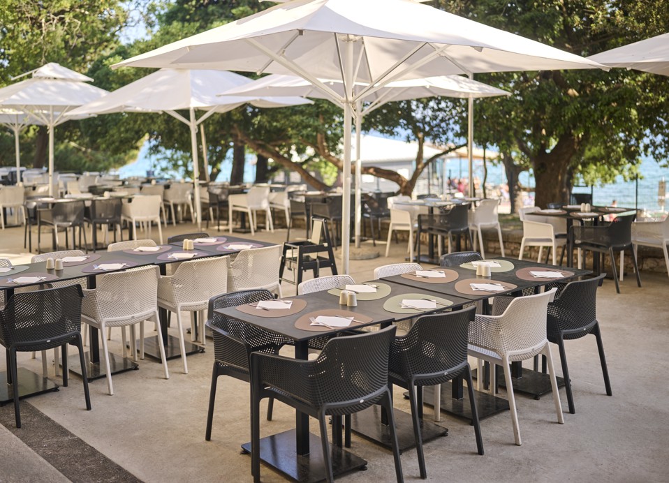 Restavracijska terasa v oljčnem vrtu s pogledom na morje in belimi senčniki, Aminess Lišanj Casa.