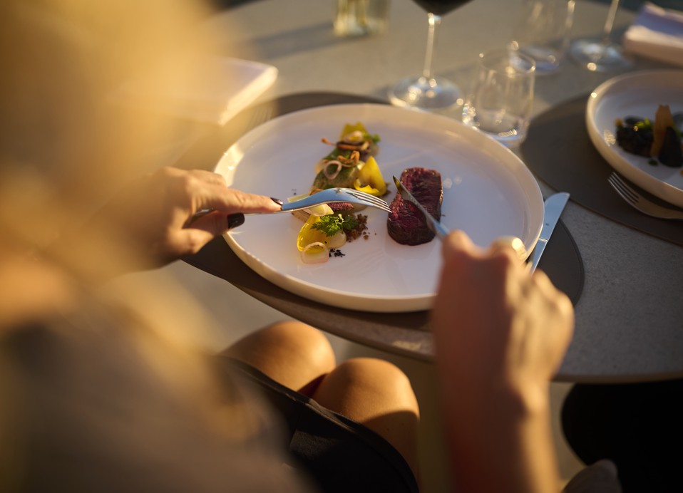 Gość delektuje się najwyższej klasy wykwintnym daniem podczas kolacji Aminess Wine & Gourmet Nights w restauracji 7 Seas