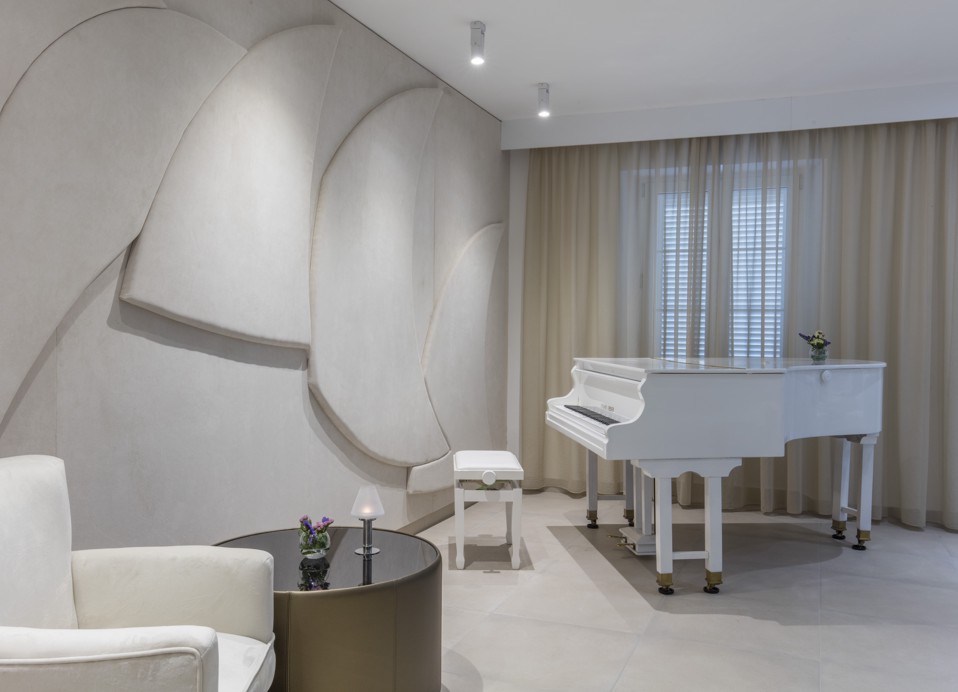 Piano bar v elegantni beli paleti znotraj hotela blizu Aminess Maradiso Bellevue Village.