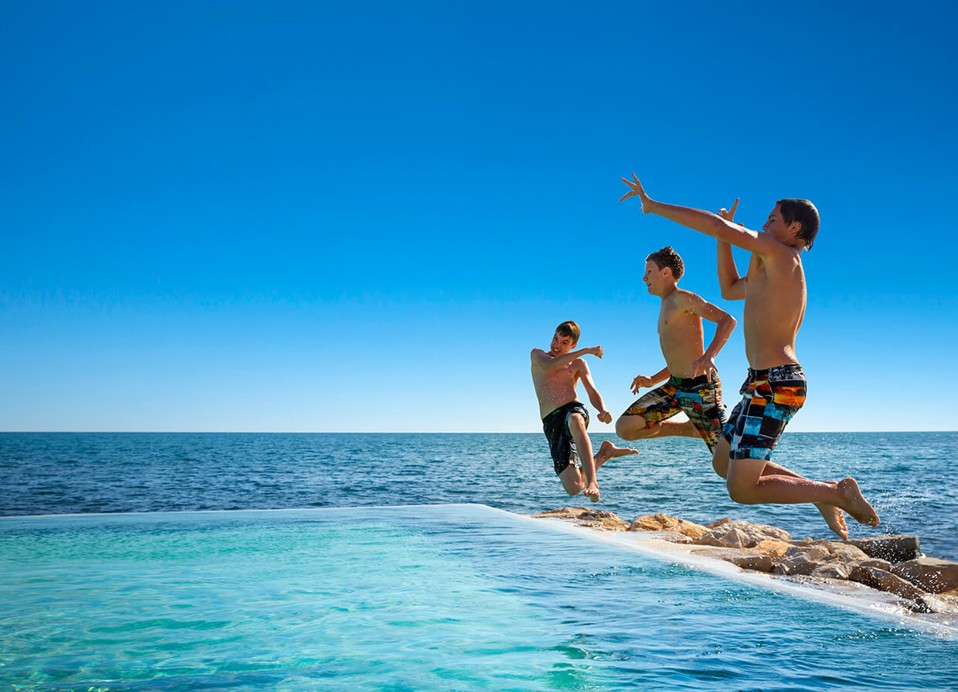 Otroci skačejo v bazenu Punto Mare v kampu Aminess Planet Camping Sirena, Novigrad, Hrvaška