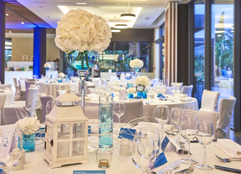 The image shows a wedding table setup in a hotel banquet hall.