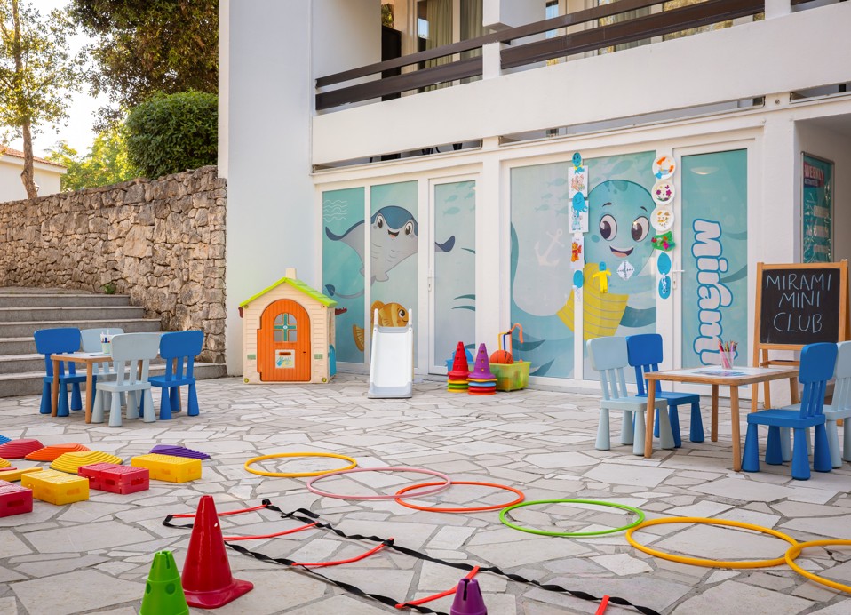 Außenbereich des Miniclubs im Aminess Vival Port9 Resort mit Spielen und Kindertischen.