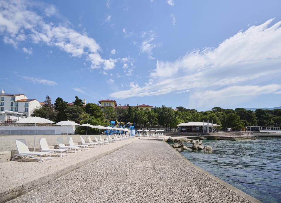 Seafront walkway with white sunbeds in front of Aminess Lišanj hotel in Novi Vinodolski.