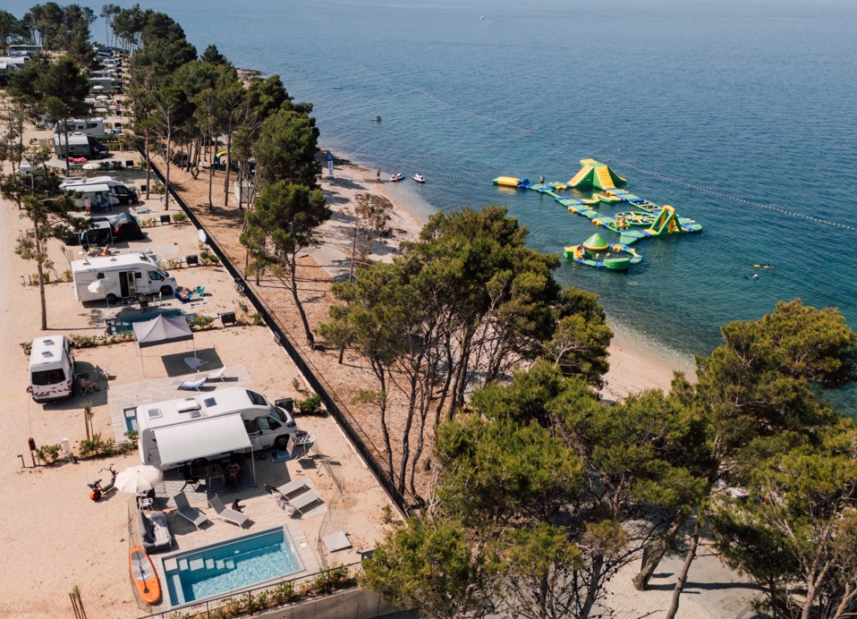 Zračni pogled na vodno igralište uz plažu u Aminess Style Camping Avalona Resortu, atrakcija puna zabave za djecu i odrasle tijekom ljetnog odmora na Pagu.