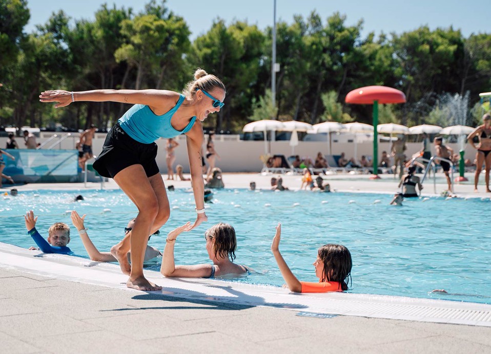 The animator gives a high five to the guests in the pool at Aminess Style Camping Avalona resort.