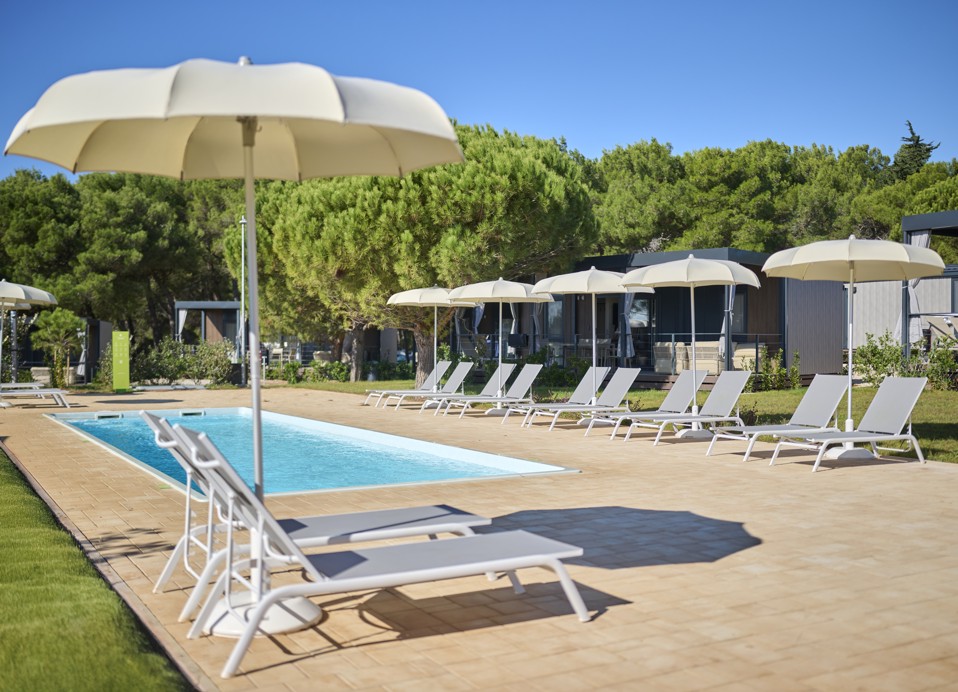 Swimming pool and sun loungers in front of the Premium Holiday Home at Aminess Planet Camping Sirena Holiday Homes, perfect for relaxation and sunbathing