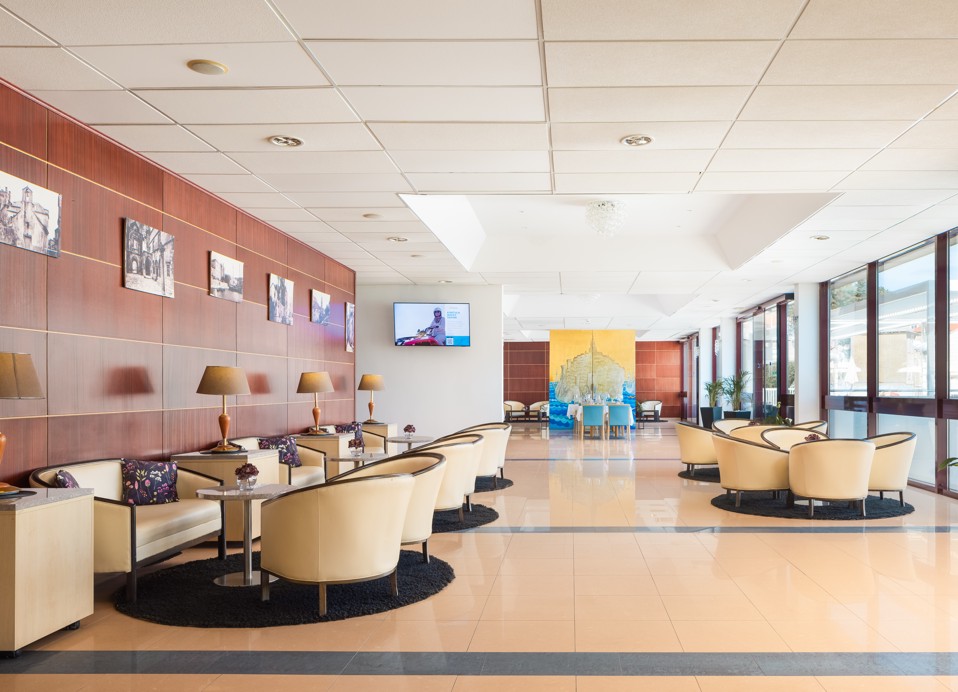 A cozy sitting area in the hotel’s aperitif bar, featuring plush seating, modern wooden decor, and indoor plants enhancing the warm and inviting atmosphere at the Maradiso Marko Polo by Aminess.