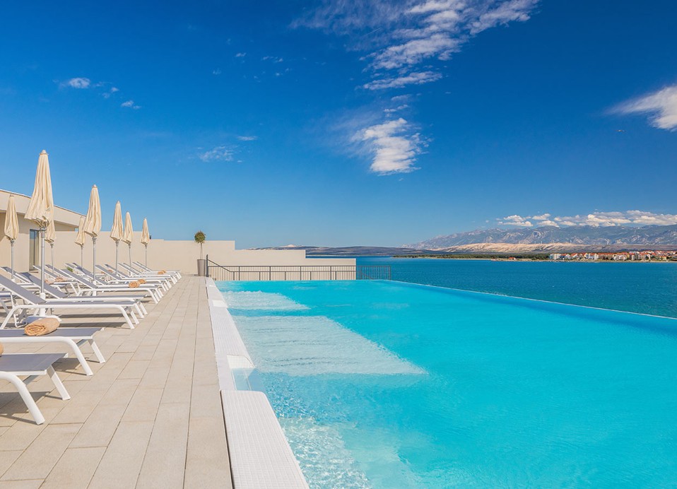 Par uživa na suncu u bazenu s pogledom na more u Aminess Style Camping Avalona resortu.